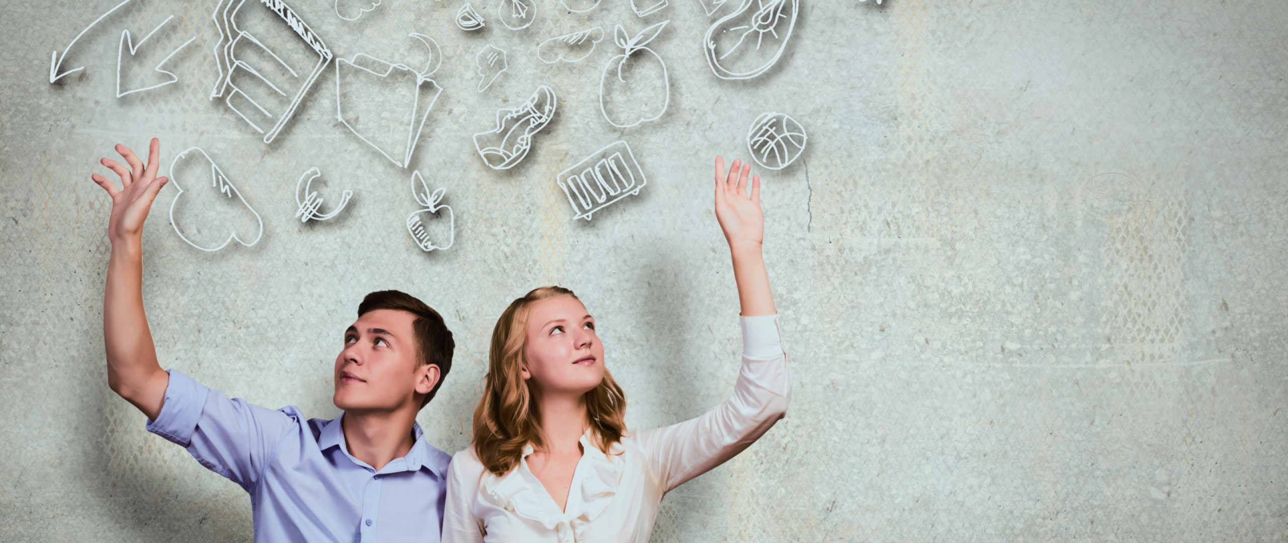 Couple sitting on floor with their arms raised and hand drawn images of their dreams behind them 